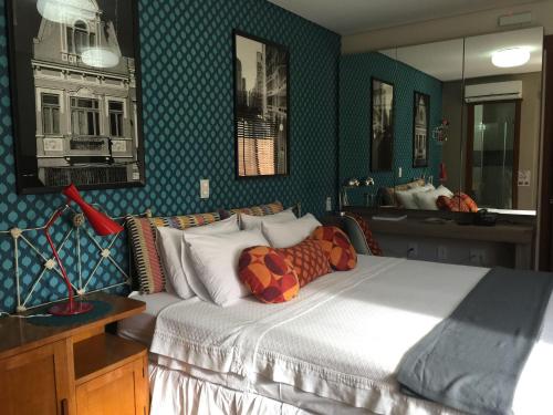a bedroom with a large bed and a mirror at Porto Retrô Residence in Porto Alegre
