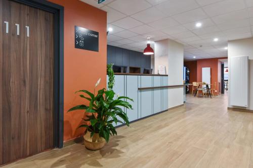 an office lobby with a potted plant in the middle at Appart'City Confort Lille - Euralille in Lille