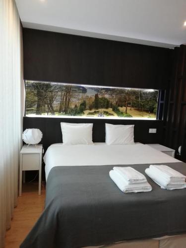 1 dormitorio con 1 cama grande y ventana grande en NEW!! Galé 404 Center Apartment (wifi, parking...) en Oporto