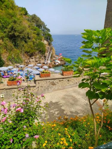 a beach with umbrellas and people on the water at Hotel Desiree in Sorrento