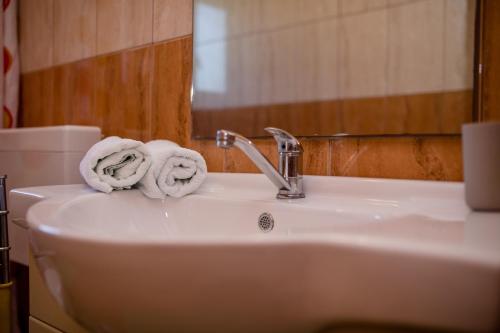 a bathroom sink with towels on top of it at Željko Apartmani in Lopar