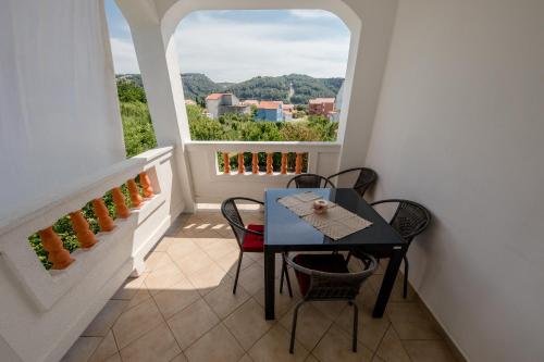 a dining room with a table and chairs and a window at Željko Apartmani in Lopar