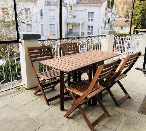 a wooden table and chairs on a balcony at Interlaken Linda Inn Lodge in Interlaken