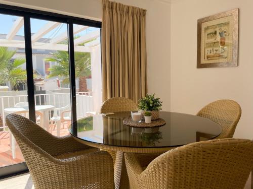 ヴィラモウラにあるMouraliz Apartments by HD PROPERTIES - Vilamoura Marinaのダイニングルーム(ガラスのテーブル、椅子付)
