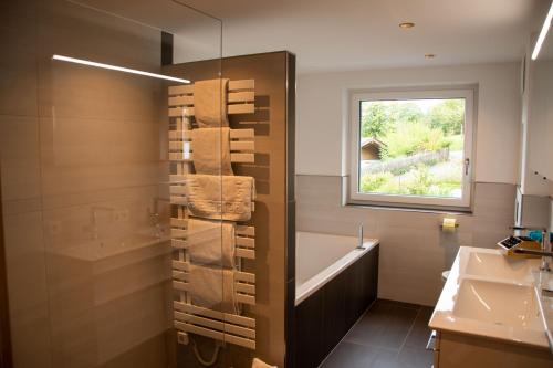 La salle de bains est pourvue d'une baignoire, d'un lavabo et d'une fenêtre. dans l'établissement Das Neue Sonnberg Living, SKI IN-SKI OUT, à Brixen im Thale