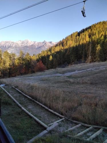 een treinspoor in een veld met bergen op de achtergrond bij STUDIO 20m2 in Puy-Saint-Vincent