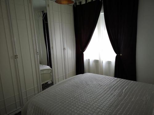 a bedroom with a white bed and a window at Apartament Darius in Târgu Ocna