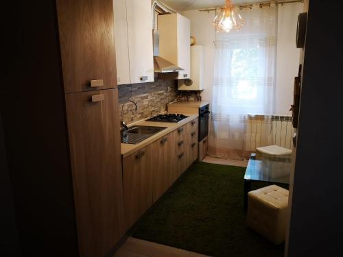 a kitchen with white cabinets and a green rug at Apartament Darius in Târgu Ocna