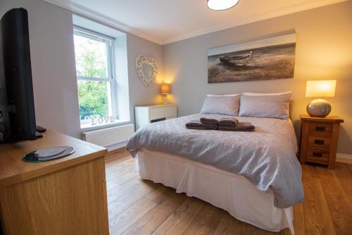 a bedroom with a bed with a dresser and a television at Sophias House- Short walk to Town and Seafront in Torquay