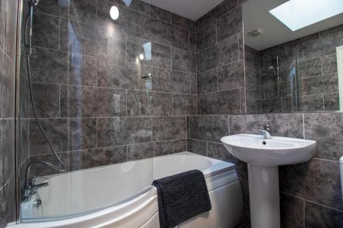 a bathroom with a sink and a bath tub and a sink at Sophias House- Short walk to Town and Seafront in Torquay