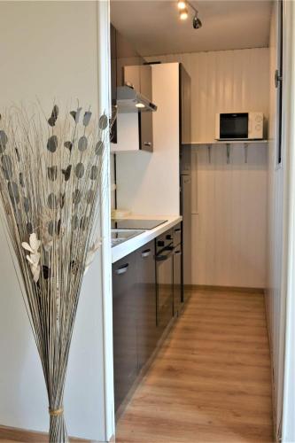 - une petite cuisine avec un vase fleuri dans l'établissement Le bohème chic !, à Gréoux-les-Bains