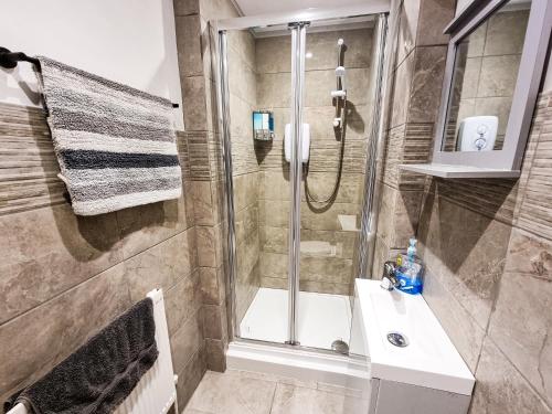 a bathroom with a shower and a sink at Newly Refurbished Flat in Central Cheltenham With Parking in Cheltenham