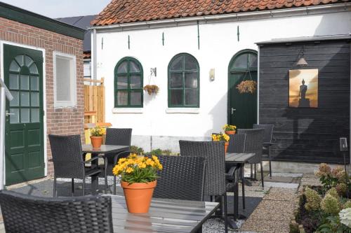 een patio met tafels en stoelen en een gebouw bij Zeeuwse Zot in Wissenkerke