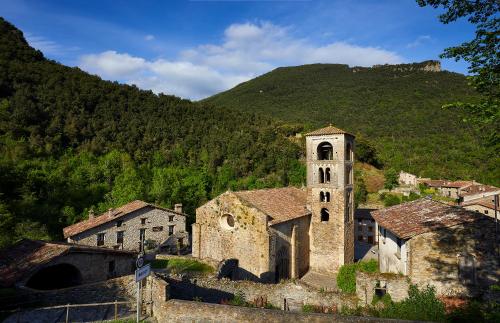 an old building with a clock tower in front of a mountain at 4LLARS in Beget