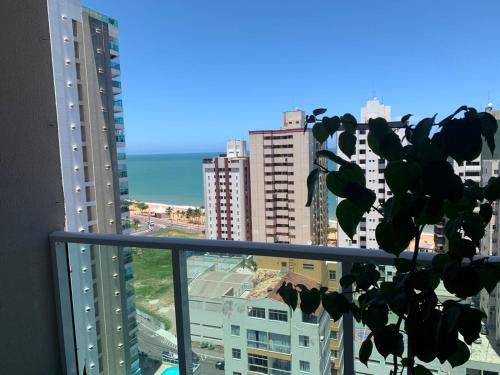 einen Balkon mit Blick auf das Meer und die Gebäude in der Unterkunft Apartamento 2 quartos Vista para o mar in Vila Velha