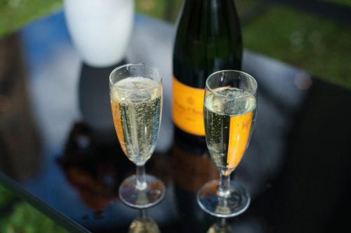 two champagne glasses sitting on a table next to a bottle at Hotel Schloss Neetzow in Neetzow