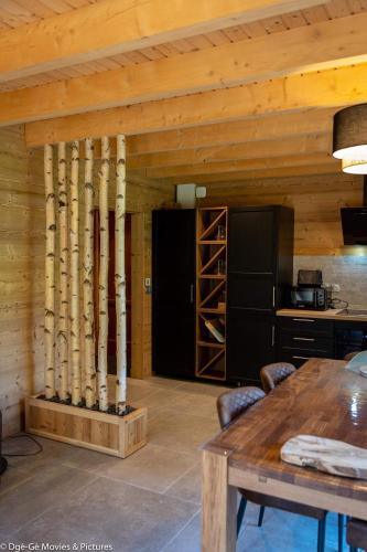 une cuisine avec un plafond en bois et une table dans l'établissement Les Jardins du Hérisson Chalet 1, à Bonlieu