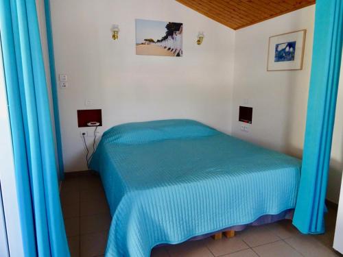 a bedroom with a blue bed in a room at Belle petite maison pour des vacances en duo sur l'île de Noirmoutier in La Guérinière