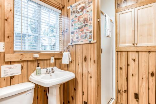 ein Badezimmer mit Holzwänden, einem Waschbecken und einem WC in der Unterkunft Gretel's House in Government Camp