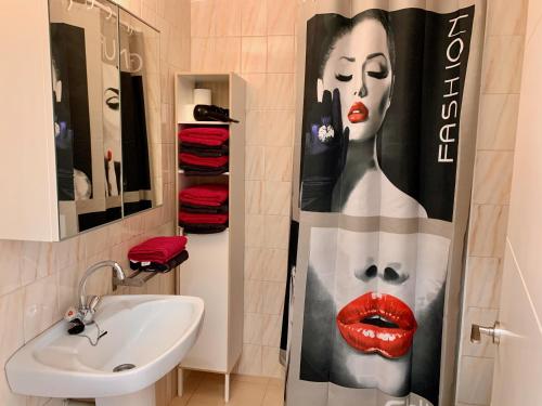 a bathroom with a shower curtain with a woman on it at Apartments Paradise Lloret in Lloret de Mar