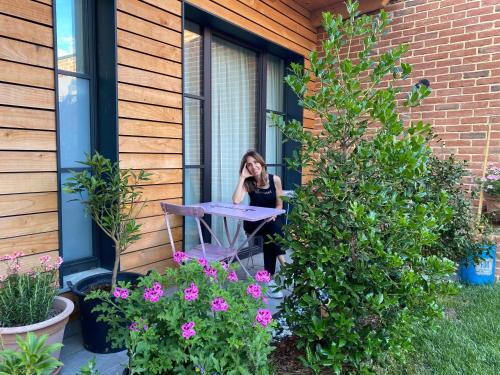a woman sitting at a table in a window at d'ARTEmisia Chambres d'hôtes in Pont-Saint-Martin