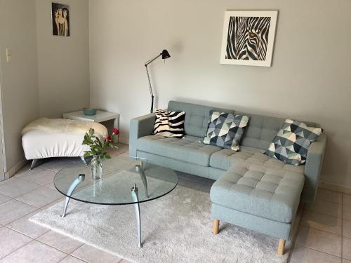 a living room with a couch and a glass table at Ghenttower in Ghent