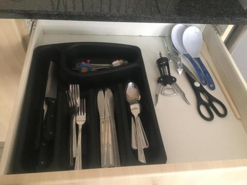 a black tray filled with utensils in a drawer at Mabungubwe Hotel Apartments - Home Away from Home in Johannesburg