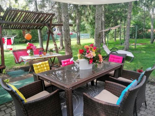 einen Tisch und Stühle mit Blumen auf der Terrasse in der Unterkunft Villa Victoria in Mosonmagyaróvár