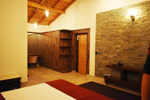 a room with a stone wall and a wooden door at Captains Paradise Luxury Resort at Mukteshwar Hill Station in Mukteswar