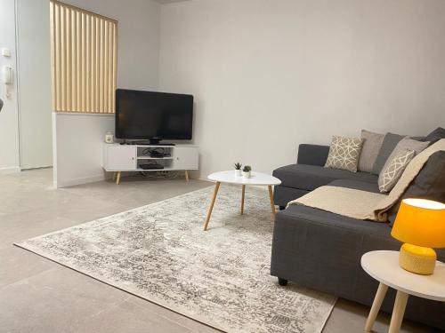 Cosy By DREAM APARTMENTS في سيريس: غرفة معيشة مع أريكة وتلفزيون