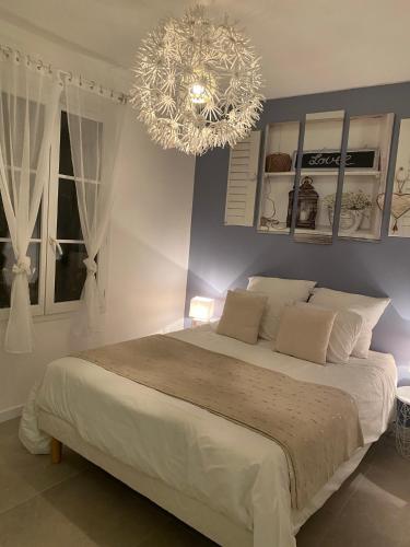 une chambre avec un grand lit et un lustre dans l'établissement Cosy By DREAM APARTMENTS, à Serris