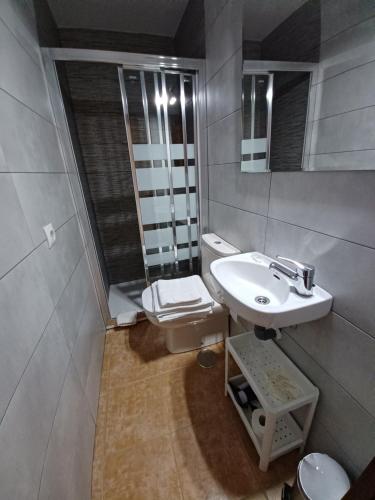 a bathroom with a sink and a toilet and a mirror at Hotel Sebreñu in Sebreño
