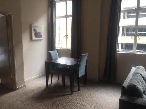 a dining room table and chairs in a room with a window at Mabungubwe Hotel Apartments - Home Away from Home in Johannesburg