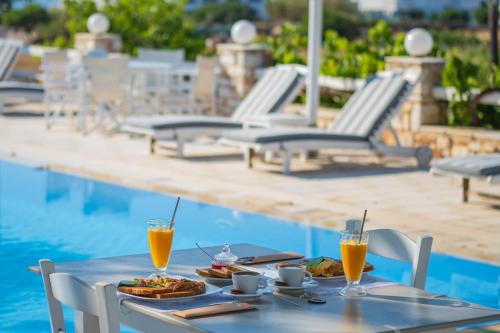 a table with food and drinks next to a pool at Margarita Studios Ambelas in Ambelas
