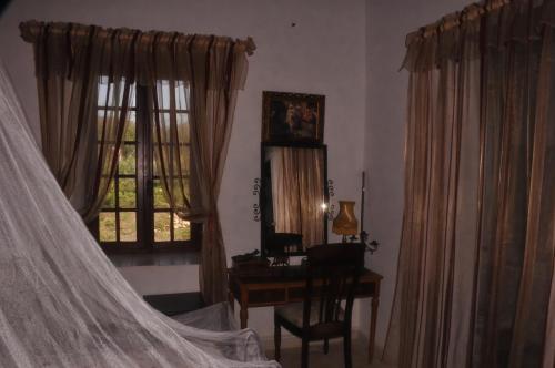 a bedroom with a desk and a bed with a curtain at ferme Walila in Douar Doukkara