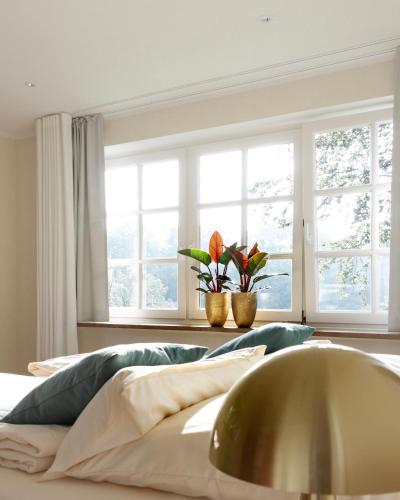 a bedroom with a bed with a window and flowers at Gut Moorbeck in Amelhausen