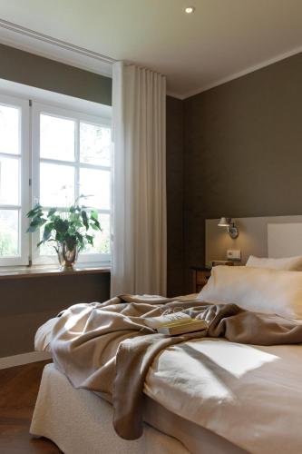 a bedroom with a large bed with a window at Gut Moorbeck in Amelhausen