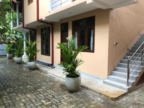 a building with potted plants in front of it at Kumar guest house & apartment in Unawatuna