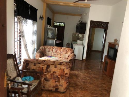a living room with a couch and a tv at Kumar guest house & apartment in Unawatuna
