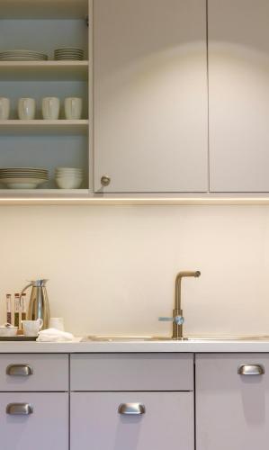 a kitchen with white cabinets and a sink at Gut Moorbeck in Amelhausen