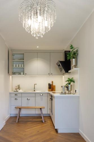 a kitchen with white cabinets and a chandelier at Gut Moorbeck in Amelhausen