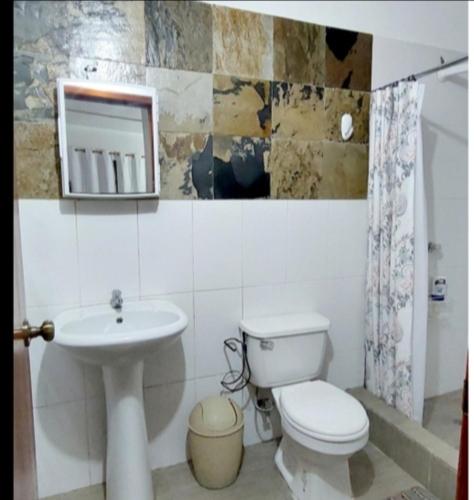 a bathroom with a toilet and a sink and a mirror at LA CASA MANGLAR Cabañas in Santa Elena