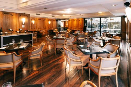 a restaurant with wooden floors and tables and chairs at Wyndham Garden Santiago Kennedy in Santiago