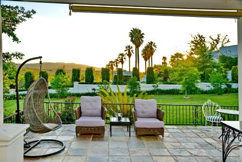 a patio with two chairs and a table at Val Du Charron Wine & Leisure Estate in Wellington