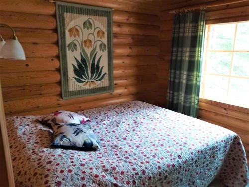 1 dormitorio con 1 cama en una cabaña de madera en Peikonpesä en Syöte