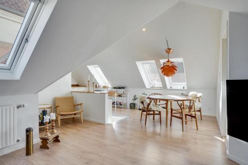 a kitchen and dining room with a table and chairs at Bath tub penthouse in the city in Aalborg