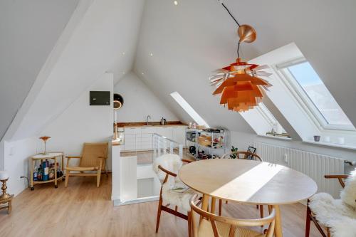 a kitchen and dining room with a table and chairs at Bath tub penthouse in the city in Aalborg