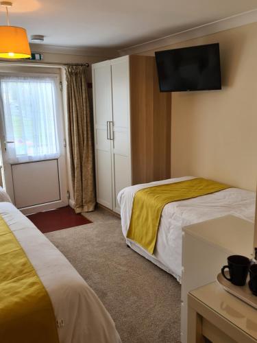 a hotel room with two beds and a television at Chilton Villa B&B in Sandwich
