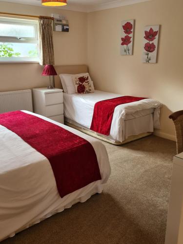 a bedroom with two beds and a window at Chilton Villa B&B in Sandwich