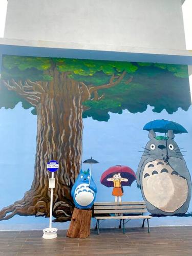 a mural of a tree and a woman with umbrellas at The Venus - Spacious Wooden TOP Floor Apartment in Sitiawan